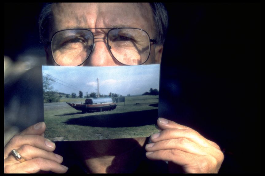 Michael Dee Cookinham holding a photo of the Chinese junk, known as the Haung Ho, which he once owned, now high and dry somewhere in Northern Cal., 1995